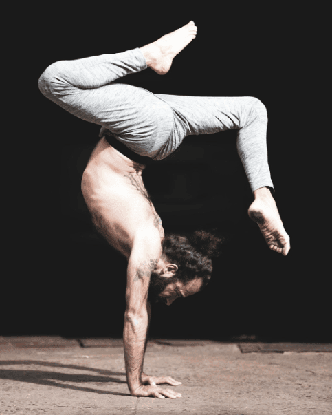 Jerome in a handstand against a dark background